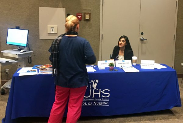 Aya Almukhtar, an AUHS Admissions Coordinator, speaking to a prospective student at Cedars-Sinai’s BSN/MSN Education Fair.